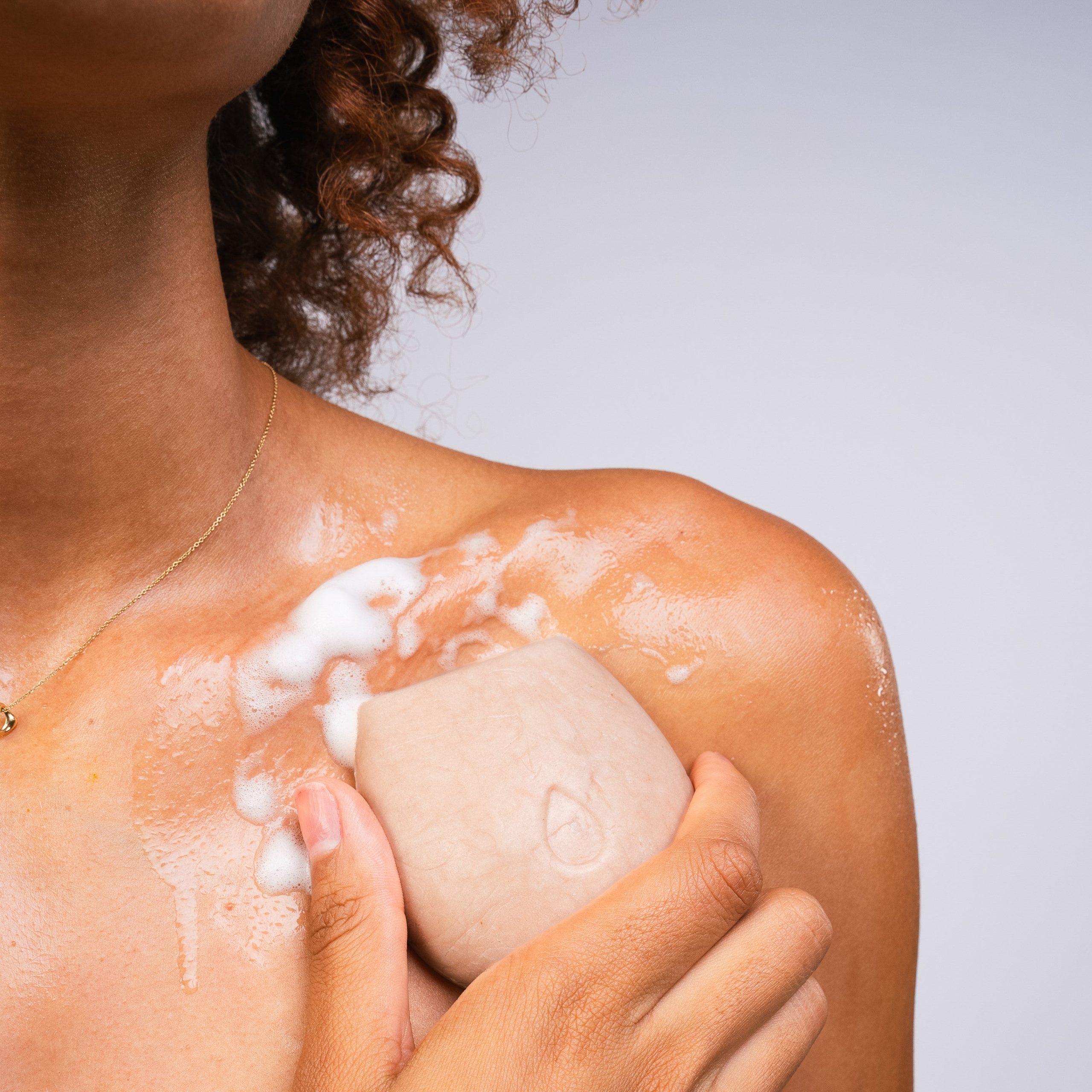 BodyWash_Exfoliate_Modelholdingbar_nopackaging_tobody_withsuds.jpg