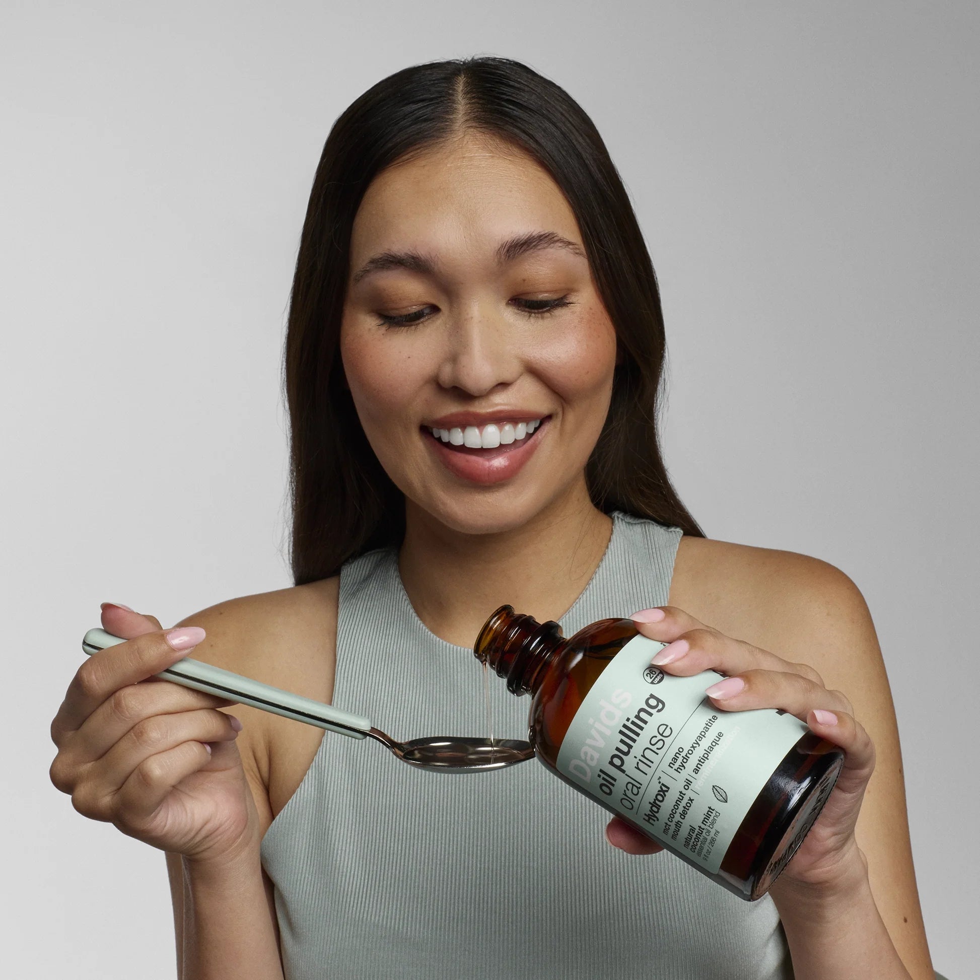 Woman_Using_Davids_Oil_Pulling_Oral_Rinse_with_a_Spoon.jpg